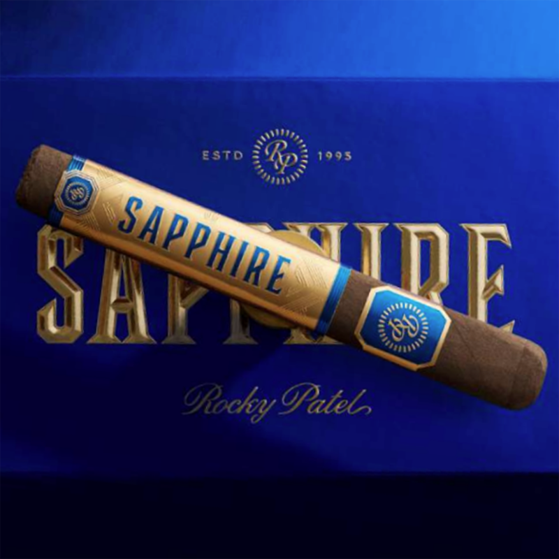 Rocky Patel Sapphire Toro cigar with Habano wrapper resting on a wooden surface, showing clean construction and minimal veining